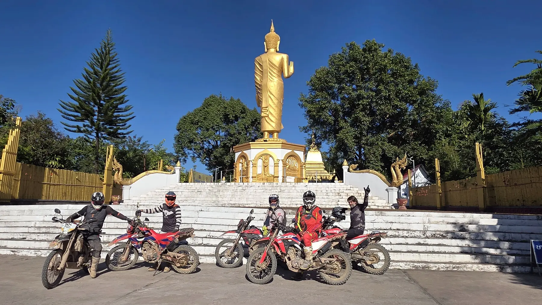 Dirt bike group visiting a Buddhist landmark in northern Laos