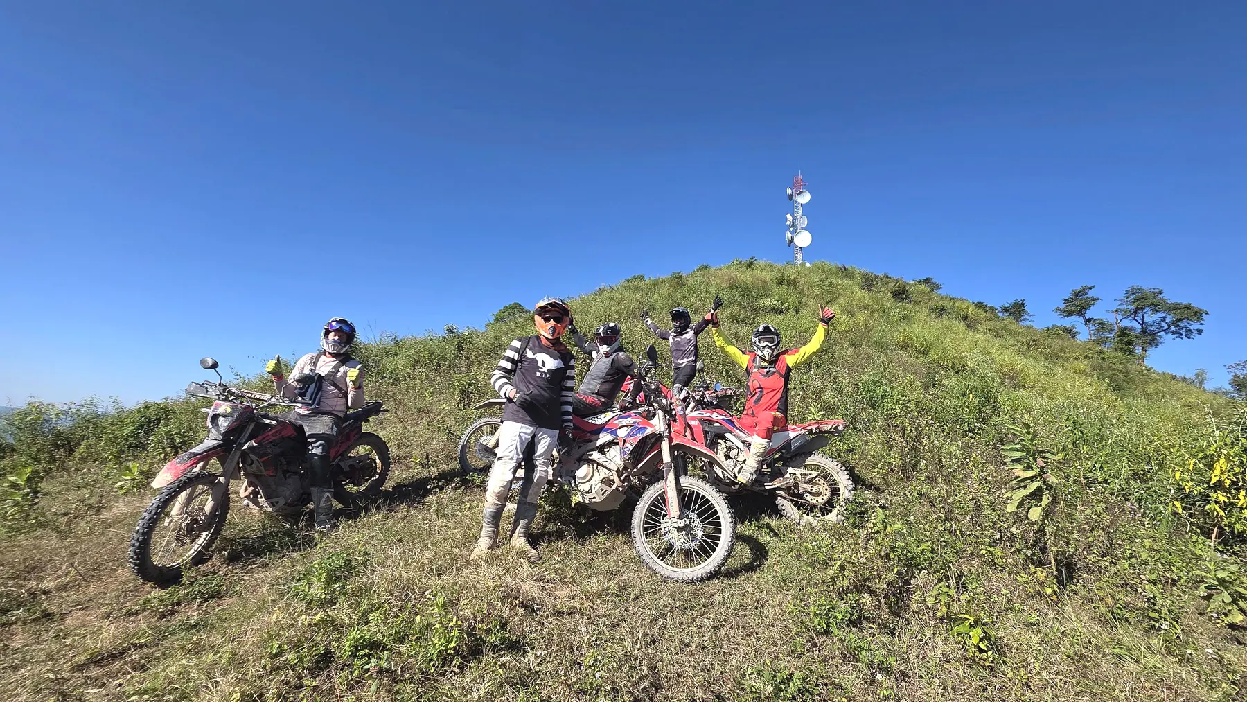 Dirt bike riders pausing on a hilltop in northern Laos