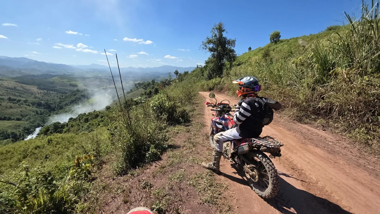 A dirt bike rider on an open mountain track.