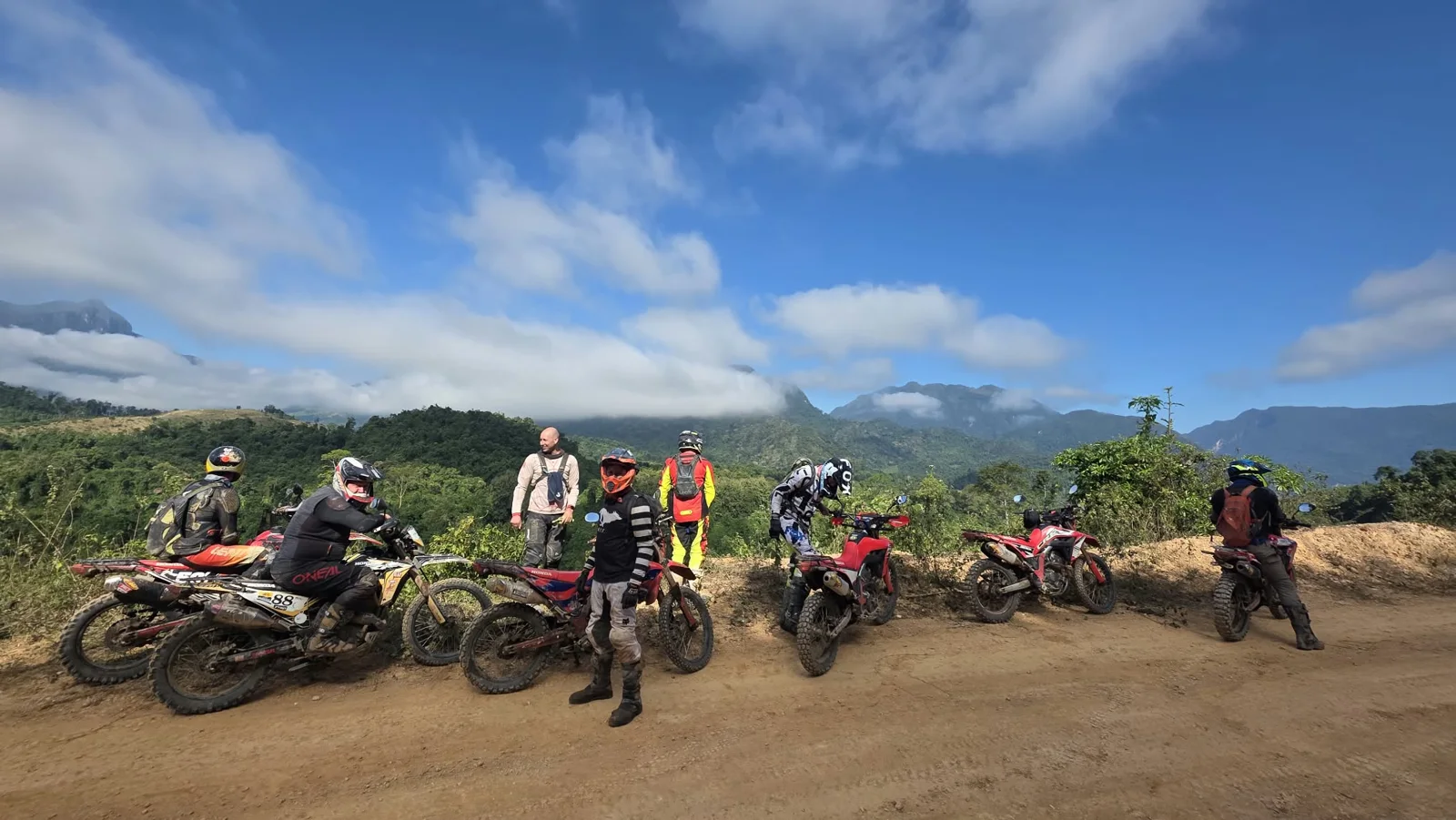 Riders and motorcycles at a mountain stop.