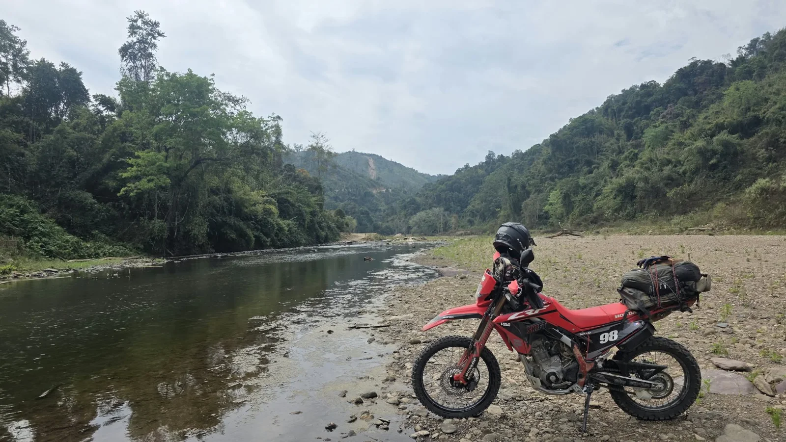 A Honda dirt bike beside the water.