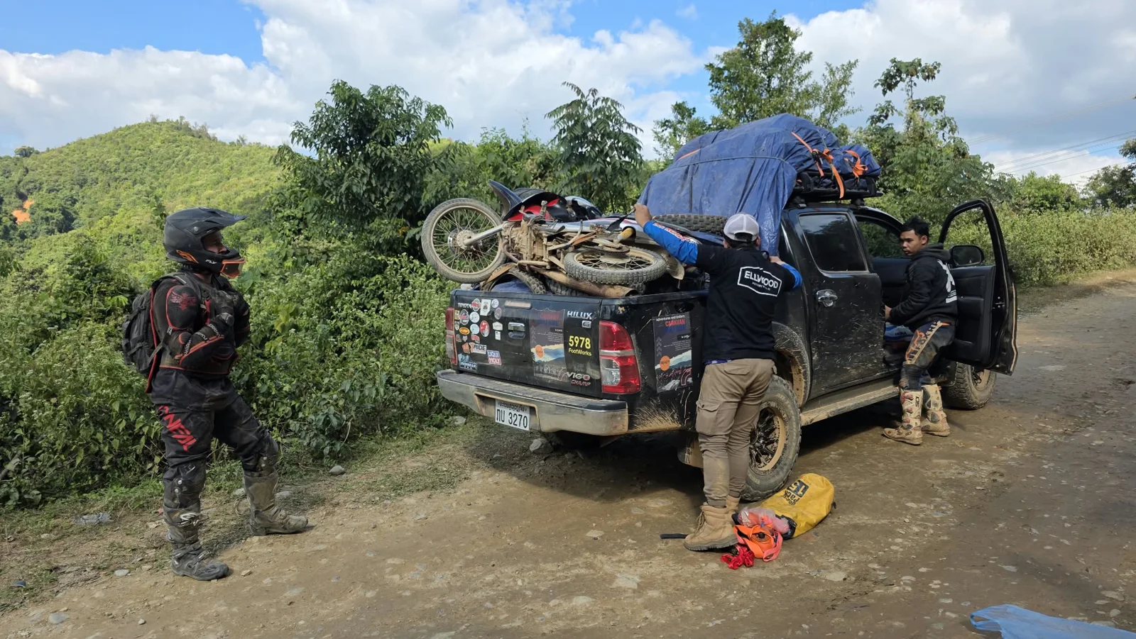A pickup and motorcycles on a rural track.