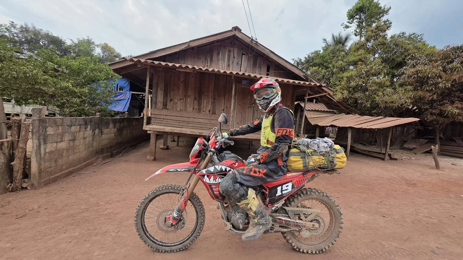 A rider passing wooden village houses.
