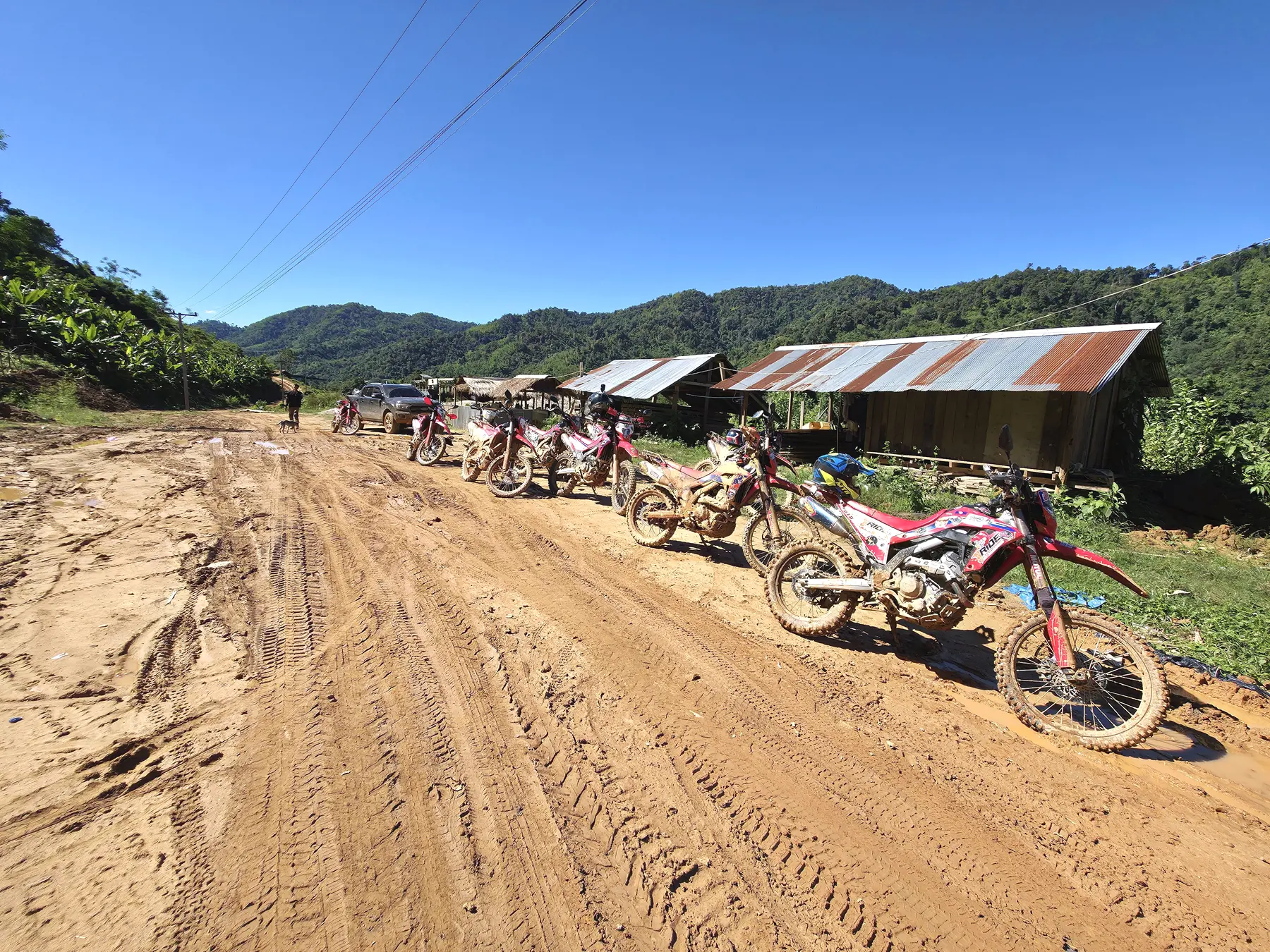 Dirt bikes on a muddy village trail in northern Laos