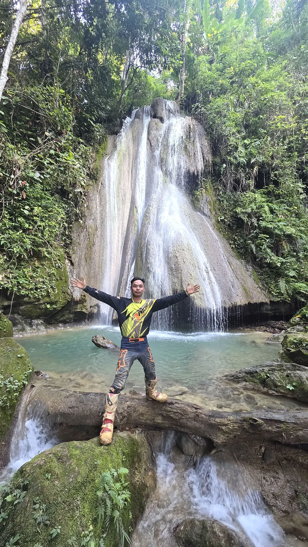 Dirt bike rider visiting a waterfall in northern Laos